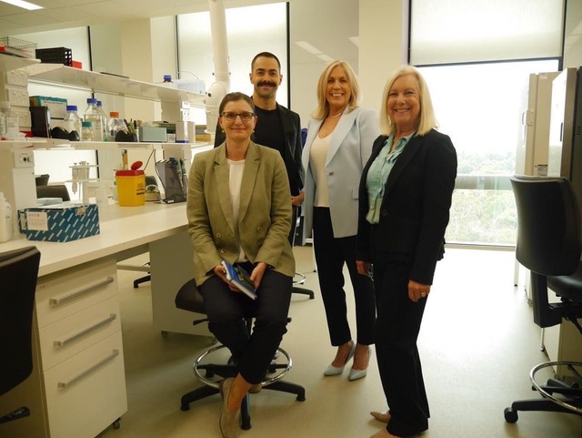 LLRF board members with a researcher in a laboratory.